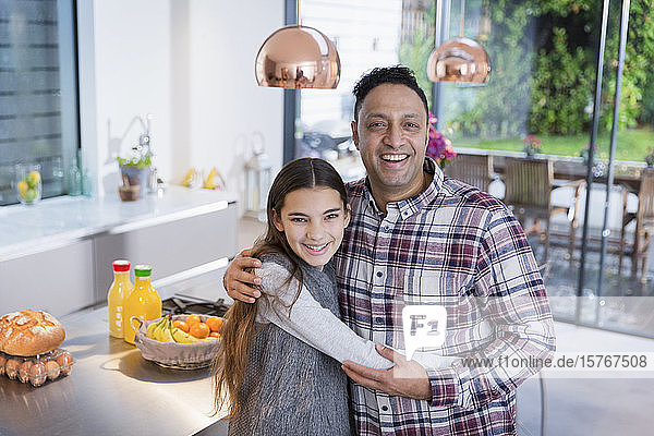 Porträt glücklicher Vater und Tochter  die sich in der Küche umarmen