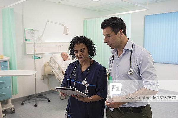 Doctors with digital tablet making rounds  consulting in hospital room