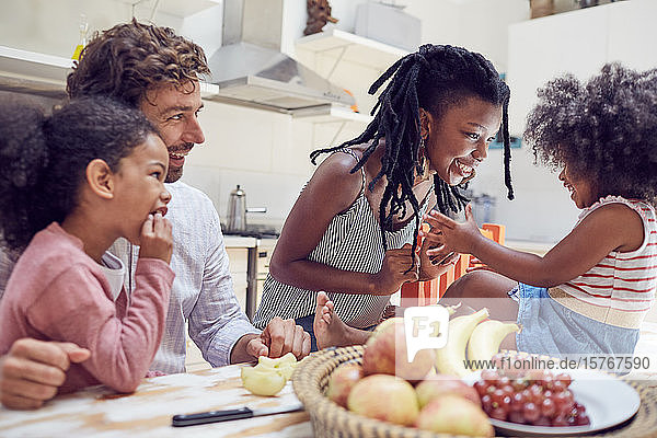 Young family eating fruit on table