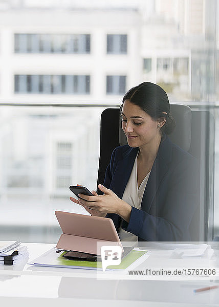 Geschäftsfrau benutzt Smartphone im Konferenzraum
