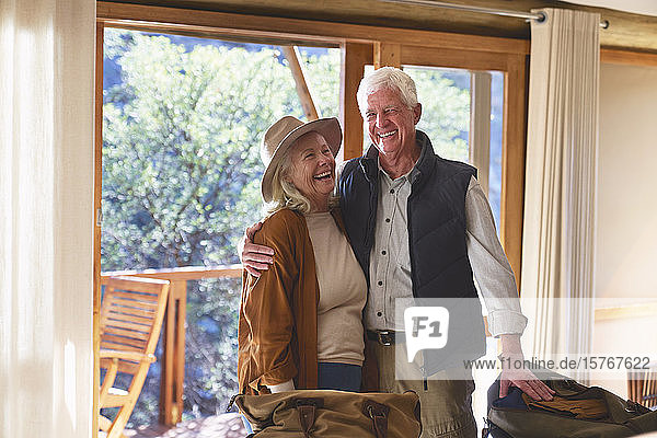 Unbekümmertes älteres Paar lacht im Hotelzimmer