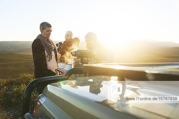 Safari-Gruppe genießt heißen Tee bei Sonnenaufgang