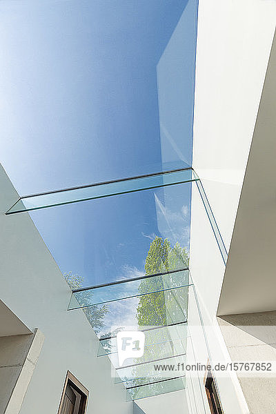 Modern glass skylight below sunny blue sky