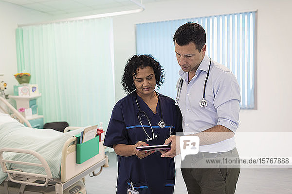 Ärzte mit digitalem Tablet bei der Visite  Beratung im Krankenhauszimmer