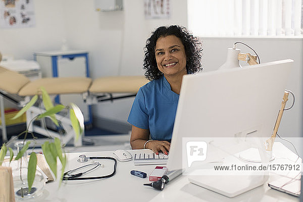 Porträt einer selbstbewussten Ärztin bei der Arbeit am Computer in einer Arztpraxis