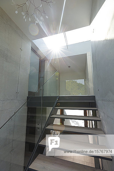 Sonnenlicht  das durch ein Oberlicht über einer modernen Treppe im Haus scheint