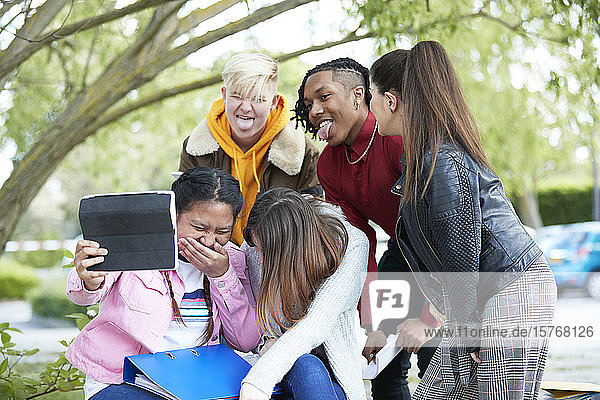 Playful happy college student friends digital tablet selfie park