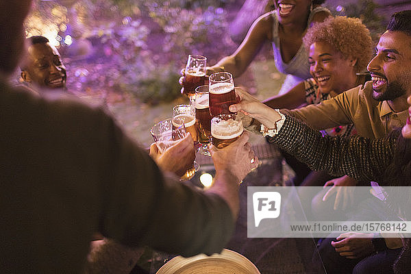 Freunde stoßen bei einer Gartenparty mit Biergläsern an