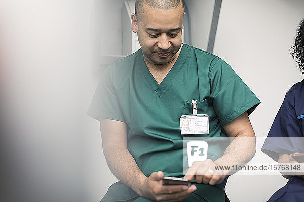 Männlicher Chirurg mit Smartphone