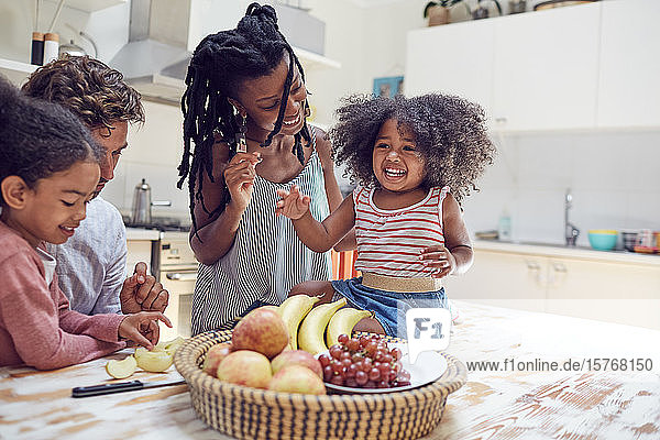 Junge Familie isst Obst in der Küche