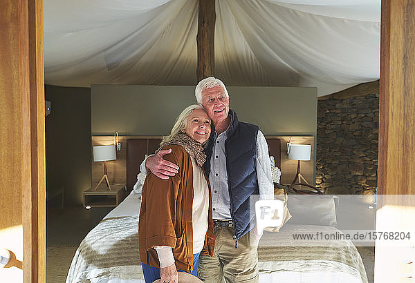 Porträt glückliches älteres Paar  das sich im Hotelzimmer einer Safari-Lodge umarmt