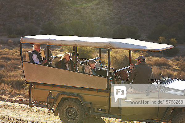 Safari-Guide und Gruppe im Geländewagen