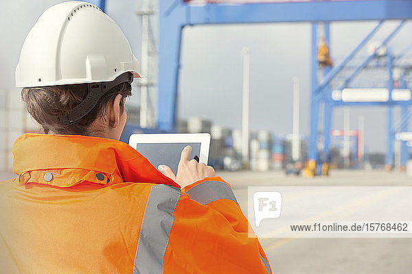 Weiblicher Hafenarbeiter mit digitalem Tablet in einer Werft