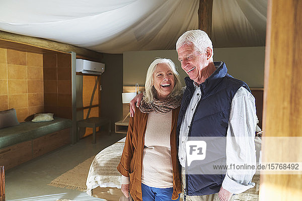 Happy senior couple laughing in hotel room