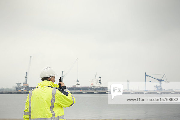 Hafenarbeiter mit Walkie-Talkie in einem Handelsdock