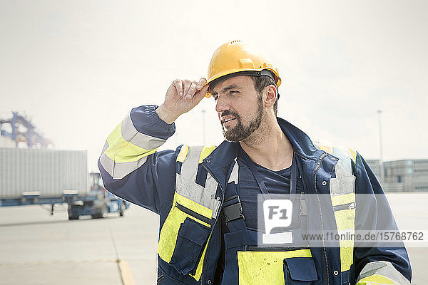 Dock worker with hard-hat at sunny shipyard