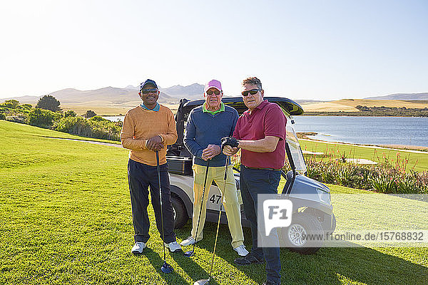 Portrait confident mature male friends golfing on sunny golf course