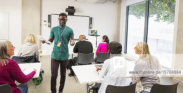 Männlicher Dozent einer Volkshochschule leitet den Unterricht im Klassenzimmer