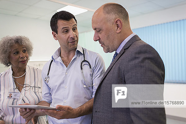 Doctors with digital tablet making rounds  consulting in hospital