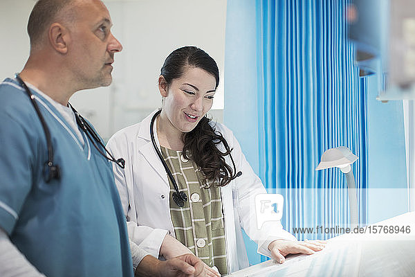 Doctors discussing paperwork in hospital room