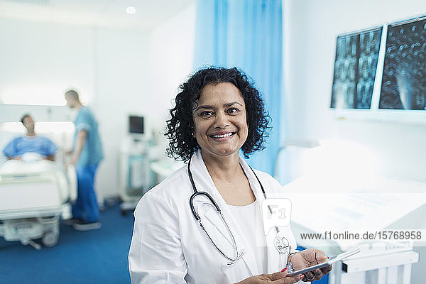 Portrait smiling  confident female doctor using digital tablet in hospital room