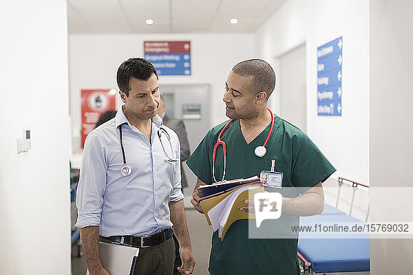 Männlicher Arzt und Chirurg bei der Visite im Krankenhauskorridor