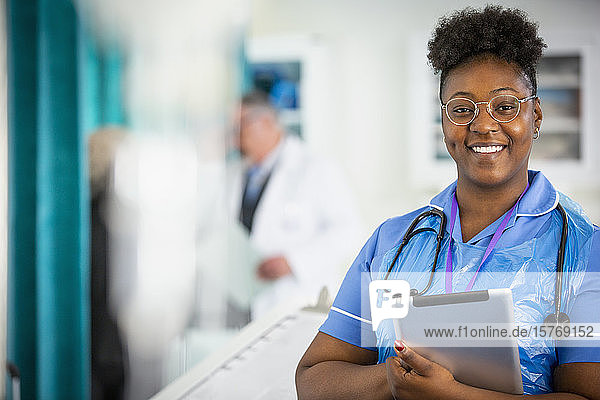 Portrait confident female nurse with digital tablet