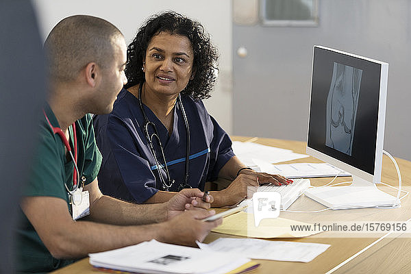 Ärzte betrachten ein digitales Röntgenbild am Computer in einer Arztpraxis