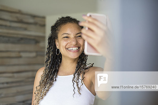 Happy young woman taking selfie with camera phone