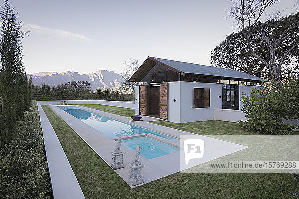 Idyllic luxury lap pool and pool house with mountains in the background