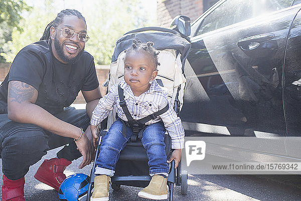 Porträt glücklicher Vater mit Kleinkind im Kinderwagen