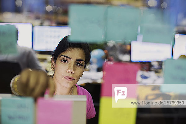 Dedicated businesswoman with adhesive notes planning in office