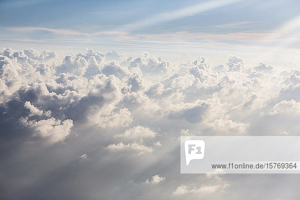 Luftaufnahme Sonnenstrahlen über flauschigen weißen Wolken