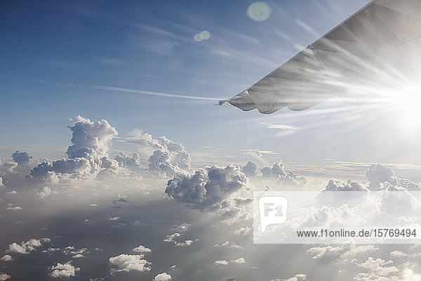 Flugzeugflügel bewegt sich durch einen ruhigen  sonnigen  bewölkten Himmel