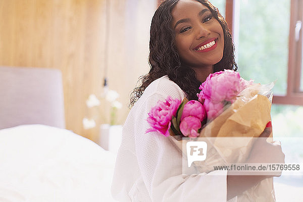 Porträt glückliche junge Frau mit Strauß rosa Pfingstrose Blumen