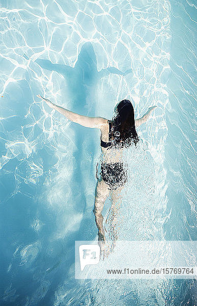 Frau im Bikini schwimmen im sonnigen Sommer Schwimmbad