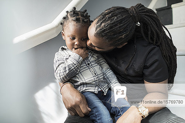 Affectionate father kissing toddler son
