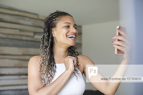 Happy young woman video chatting with smart phone