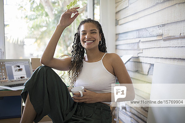 Porträt glückliche sorglose junge Frau im Heimbüro