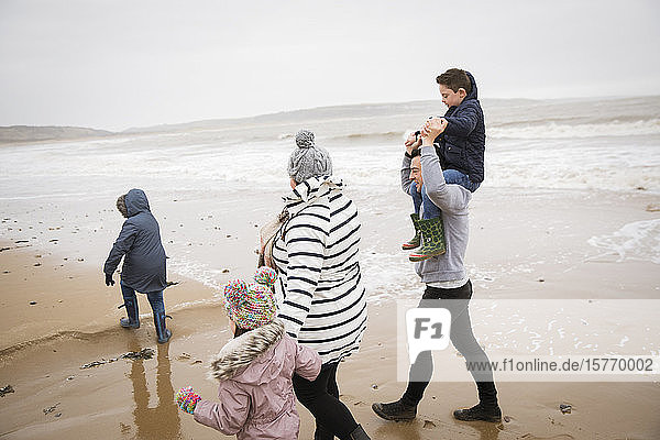 Family walking on winter ocean beach