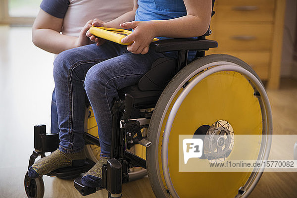 Junge im Rollstuhl mit digitalem Tablet