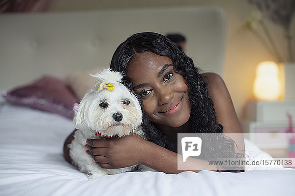 Portrait glückliche junge Frau mit Hund auf Bett