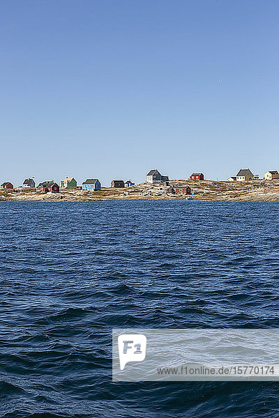 Häuser an sonniger  abgelegener Meeresküste Diskobucht Westgrönland