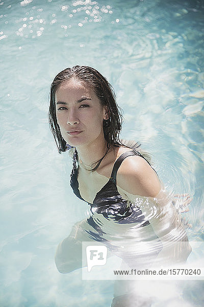 Porträt selbstbewusste Frau schwimmen in sonnigen Sommer Schwimmbad