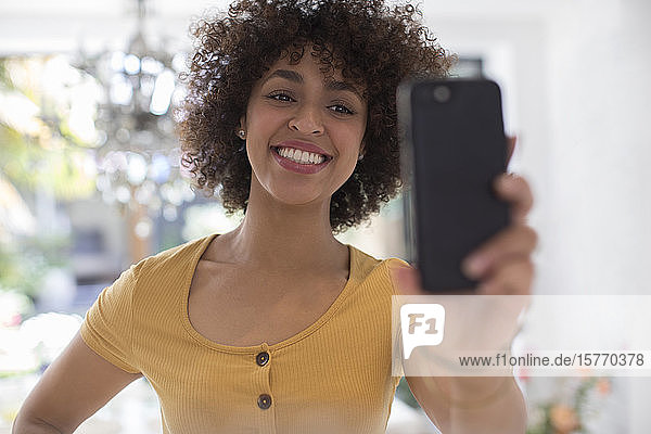 Glückliche junge Frau nimmt Selfie mit Kamera-Handy