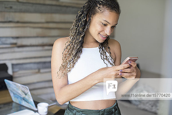 Junge Frau schreibt eine SMS mit einem Smartphone