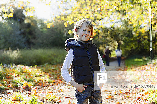 Portrait confident boy in sunny autumn park