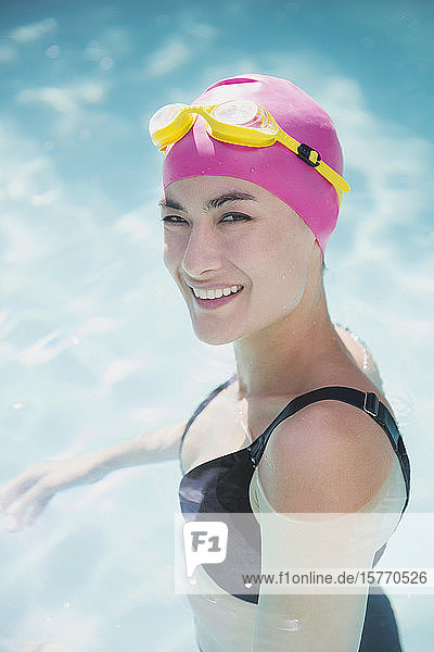Porträt selbstbewusste Frau mit Badekappe und Schwimmbrille im Schwimmbad