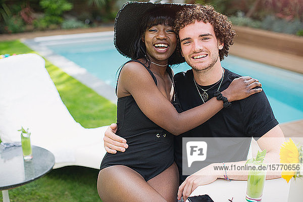 Portrait glückliches junges multiethnisches Paar entspannt am Pool
