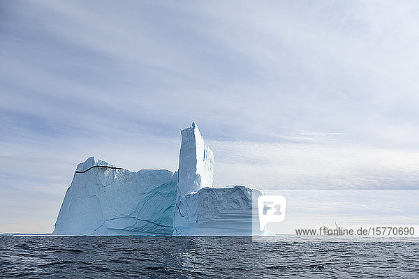 Majestätische Eisbergformation über dem sonnigen Atlantischen Ozean Grönlands